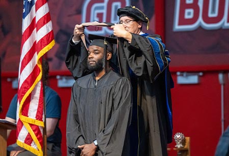 A graduate student receiving their sash