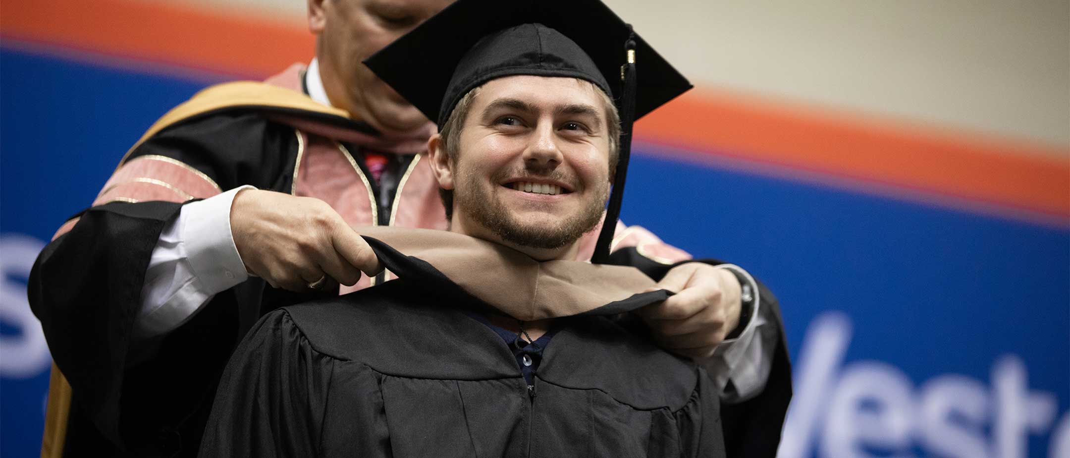 A graduate student receiving their sash