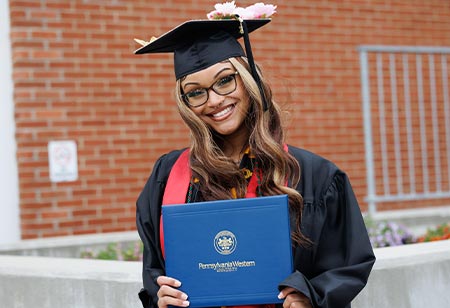 A student posing with her diploma