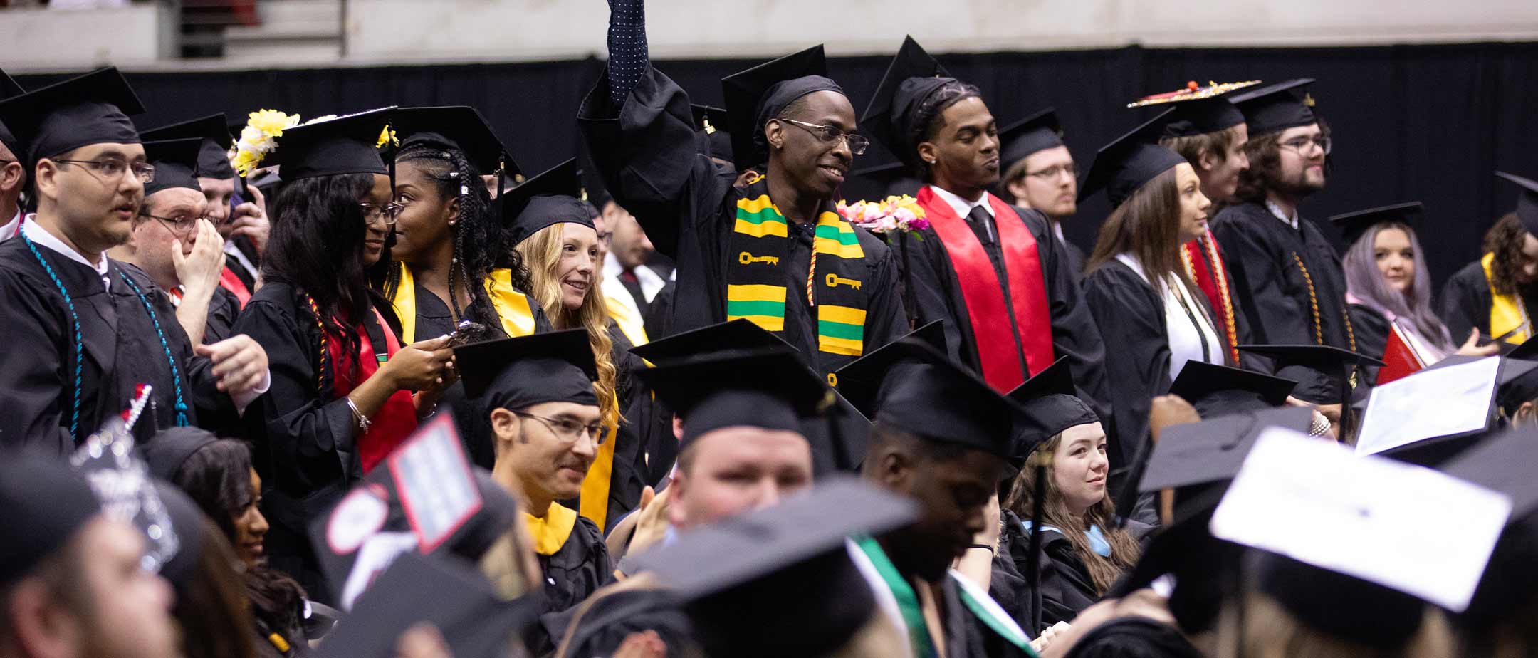 An undergraduate student holding their diploma