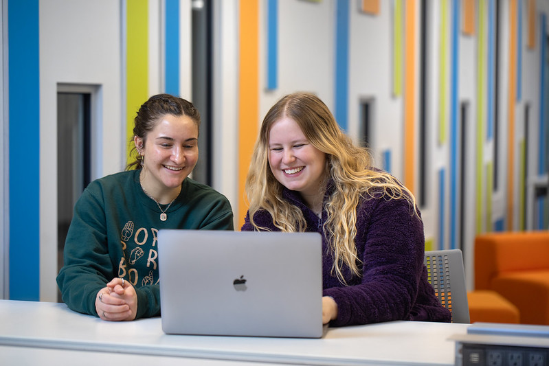 PennWest students using a computer in the library. 