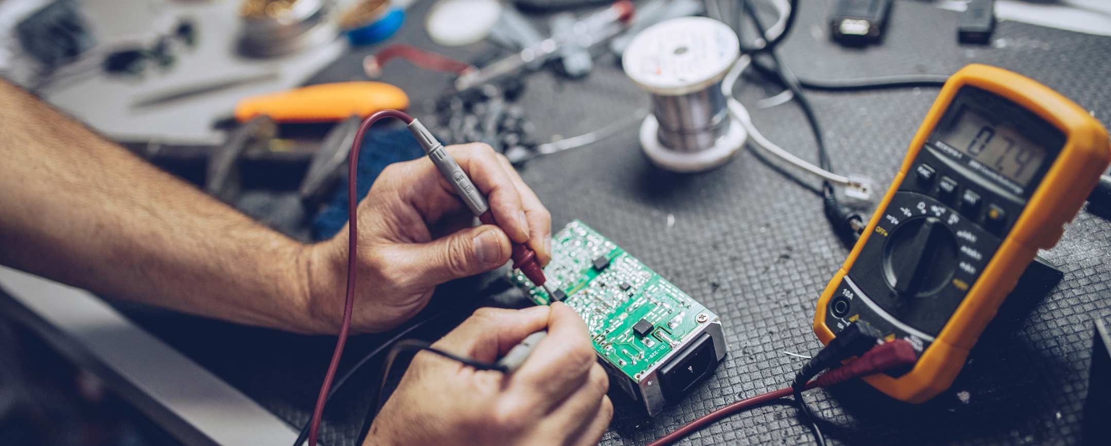 A student using a multi-meter on a circuit board