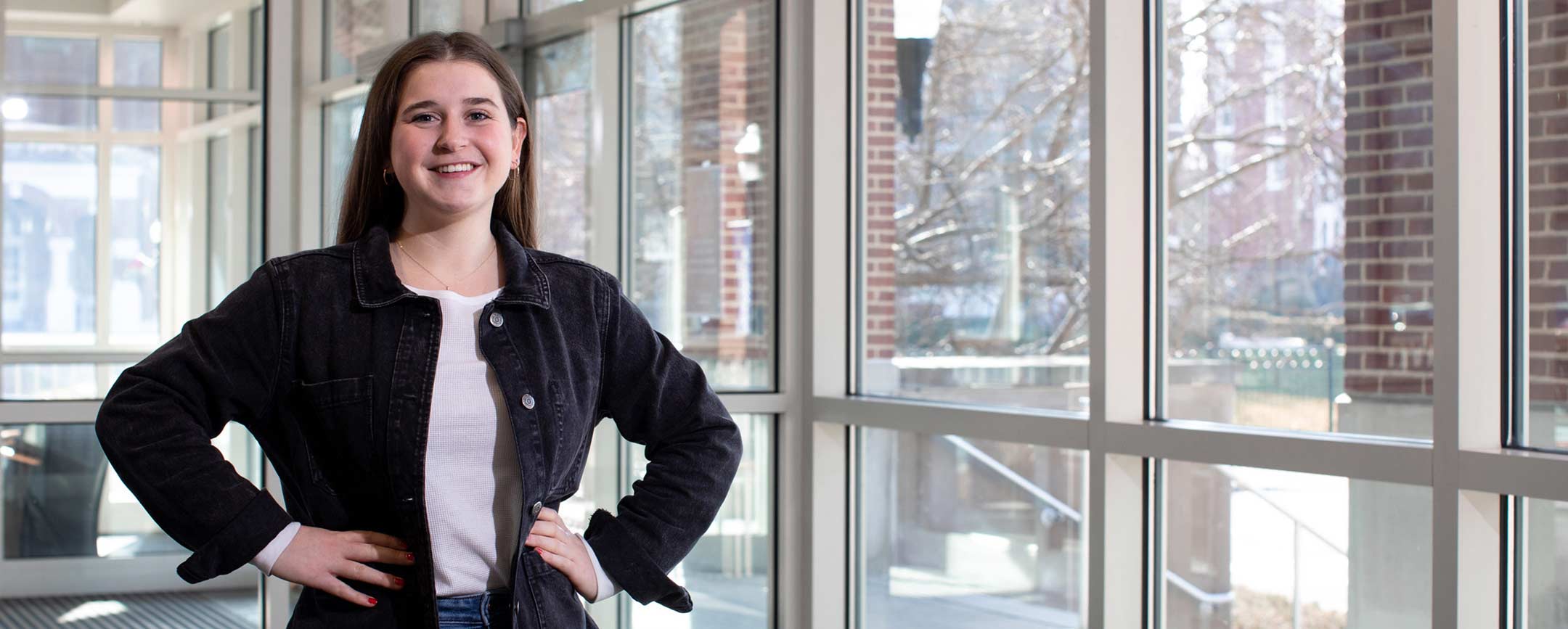 Student at PennWest posing for a photo outside of academic building. 