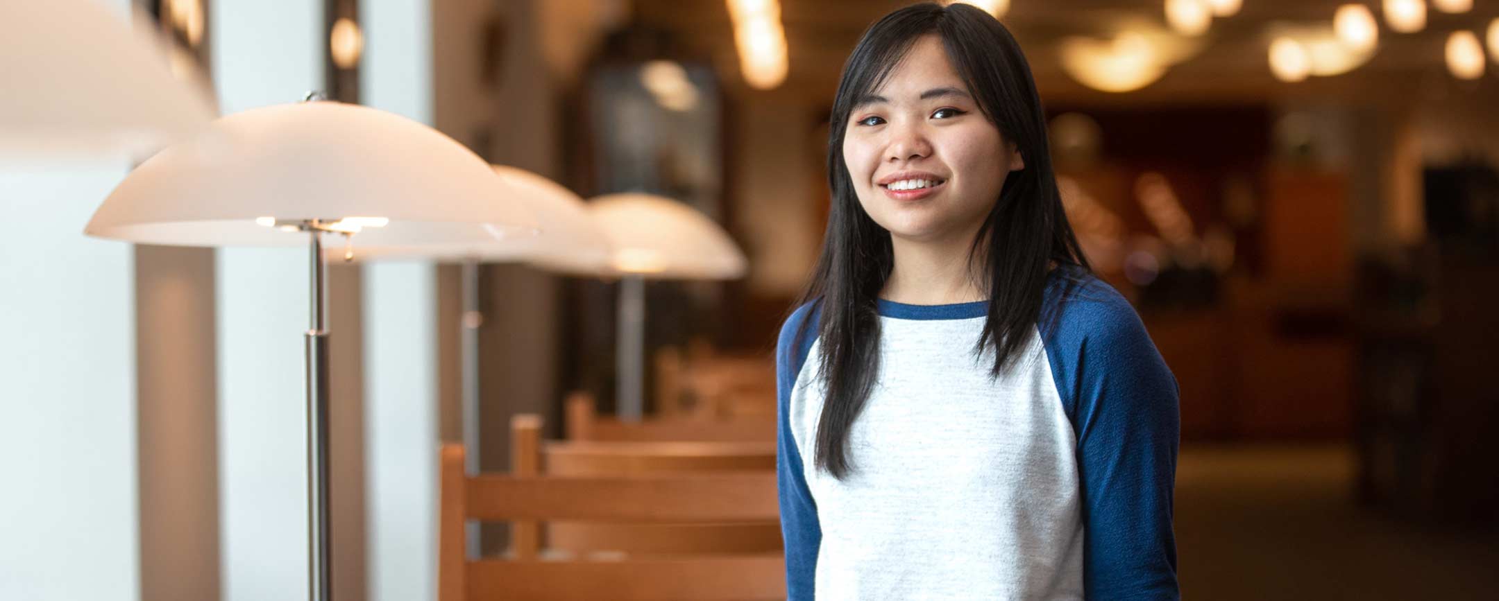 A student standing by some lamps