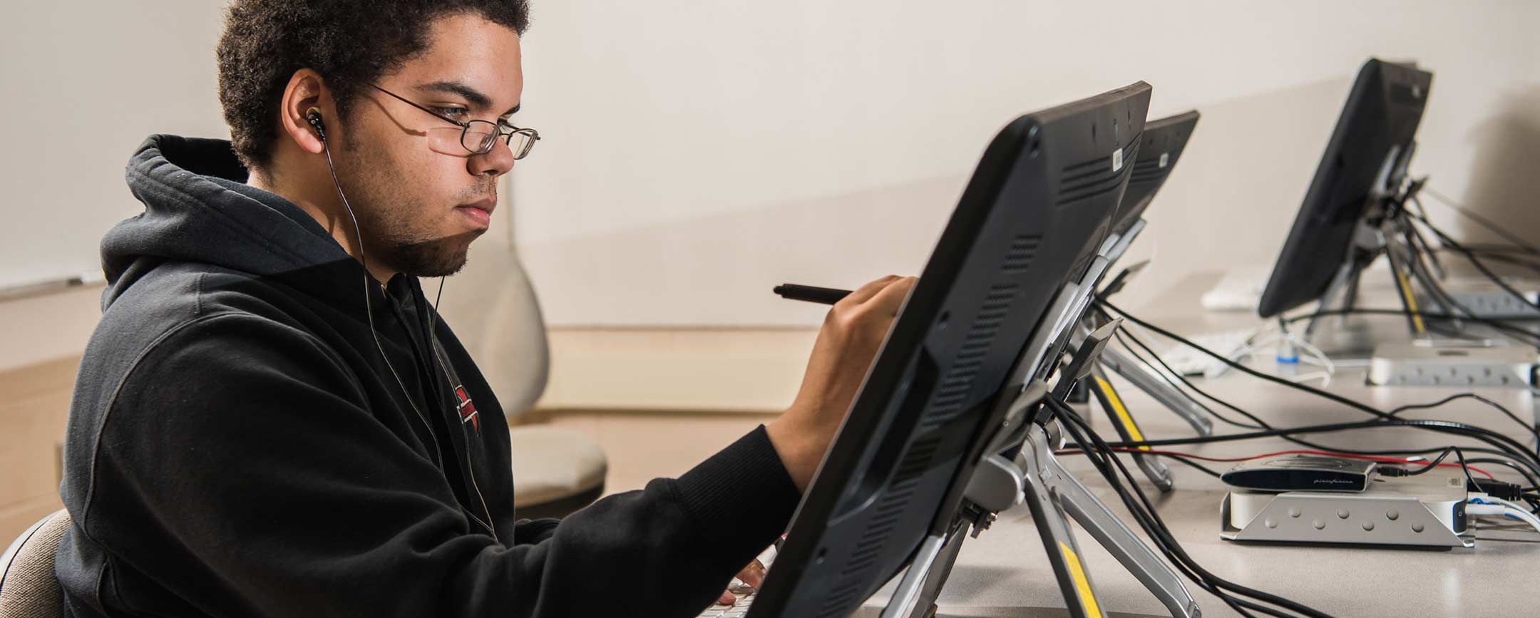 A bachelor's of graphic design student drawing on a computer.