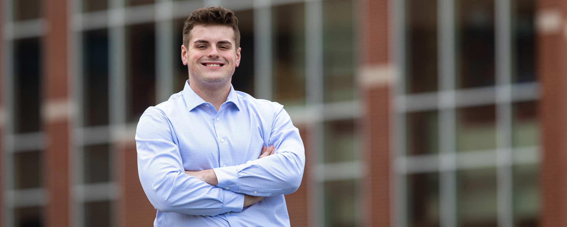 A business student standing in front of a building