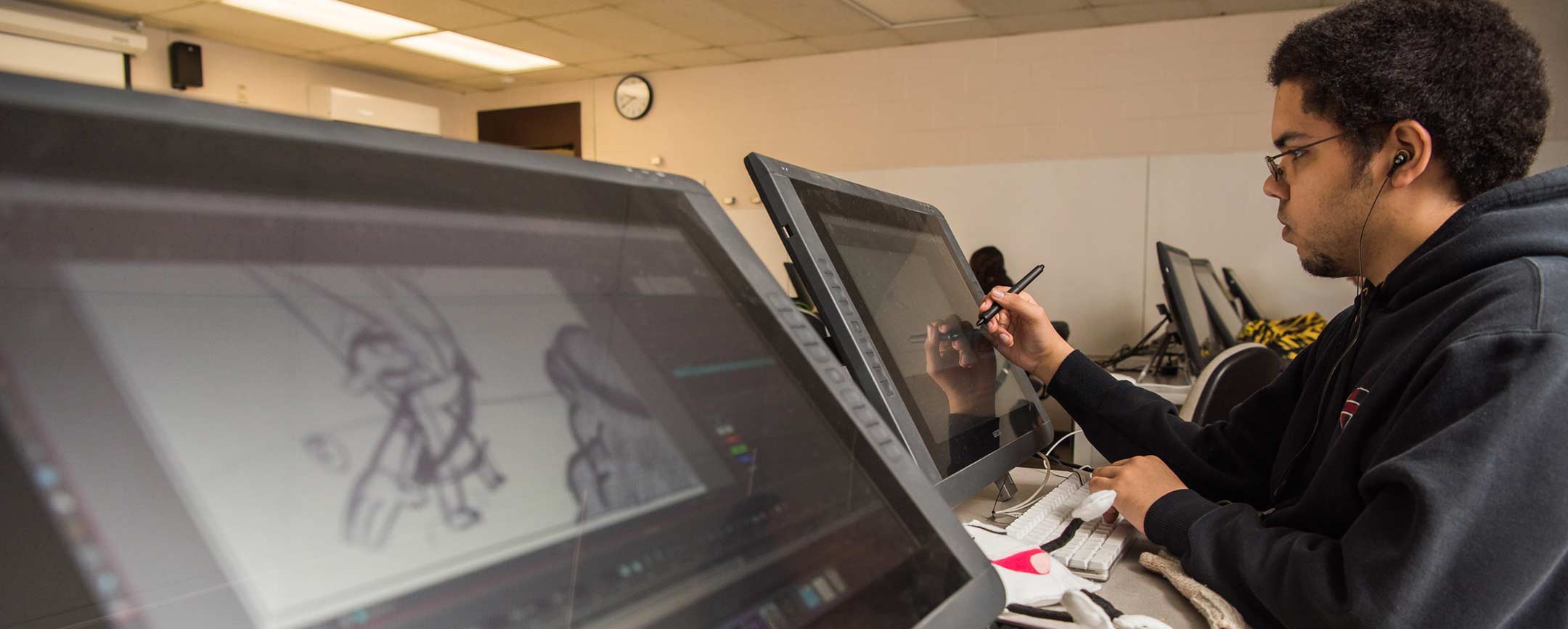 A student illustrating in a media arts program at Pennsylvania Western University (PennWest)