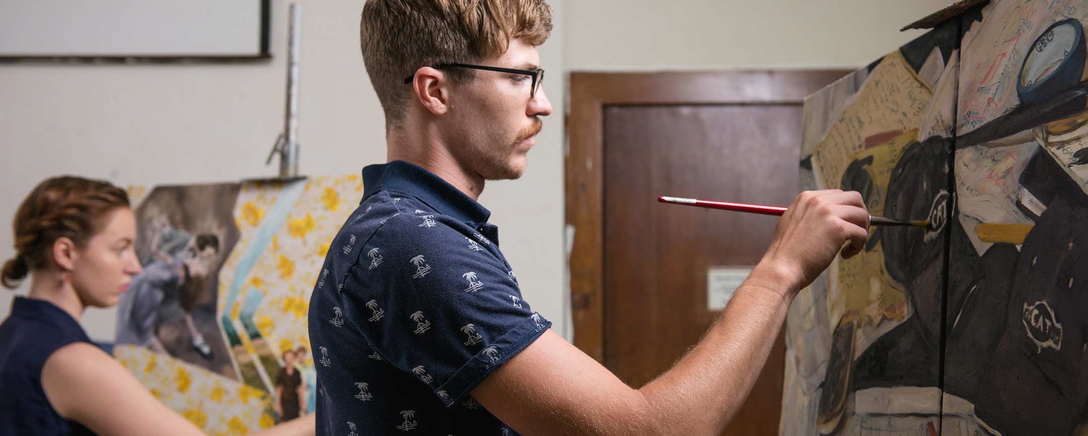 A BFA in Studio Arts student paints on a canvas at Pennsylvania Western University (PennWest)