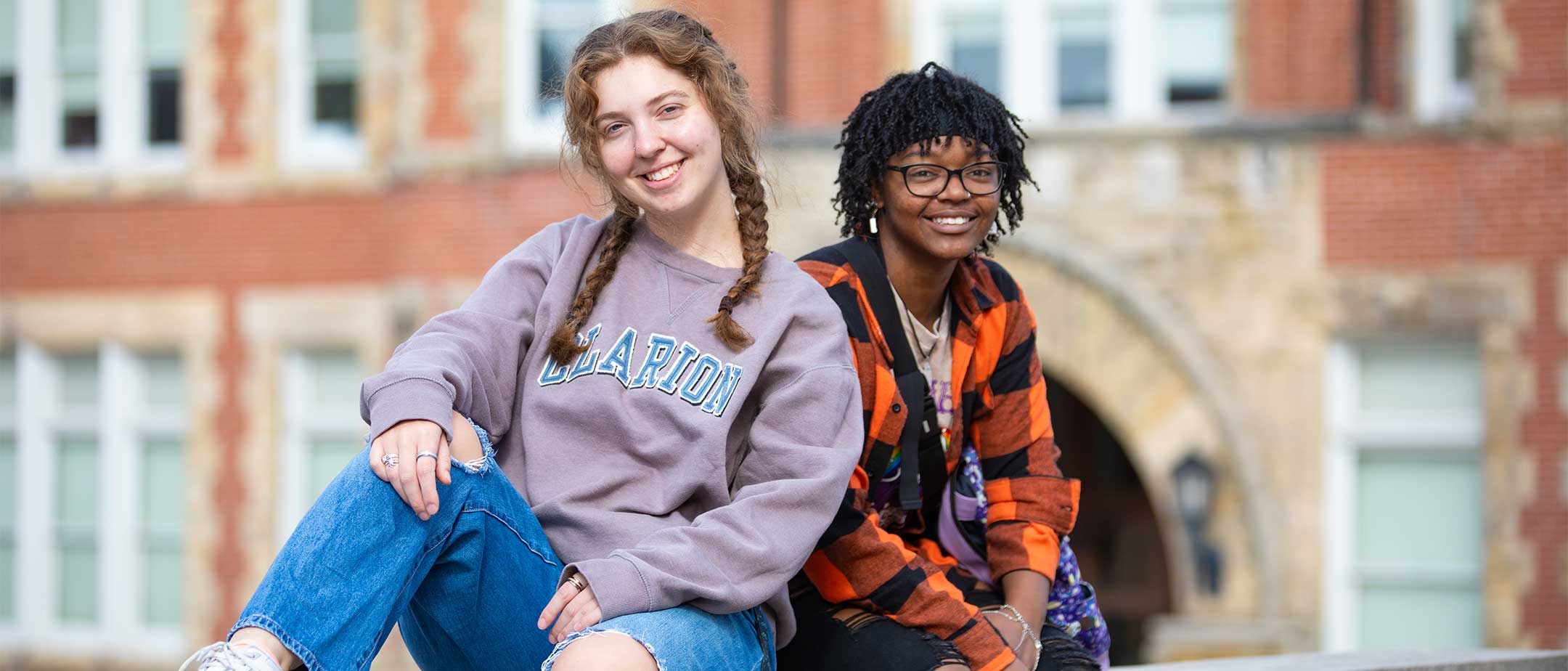 Students sitting on a brick wall