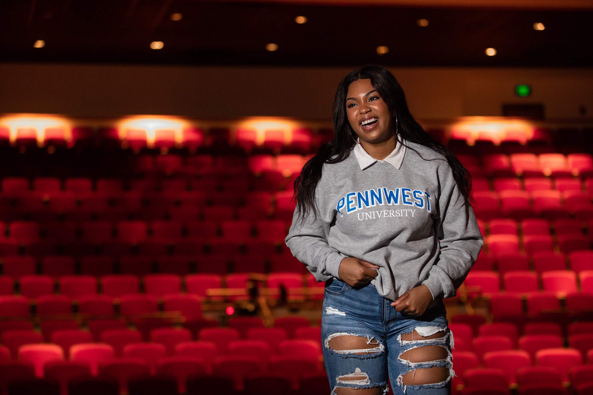 PennWest Student smiling in a theater.