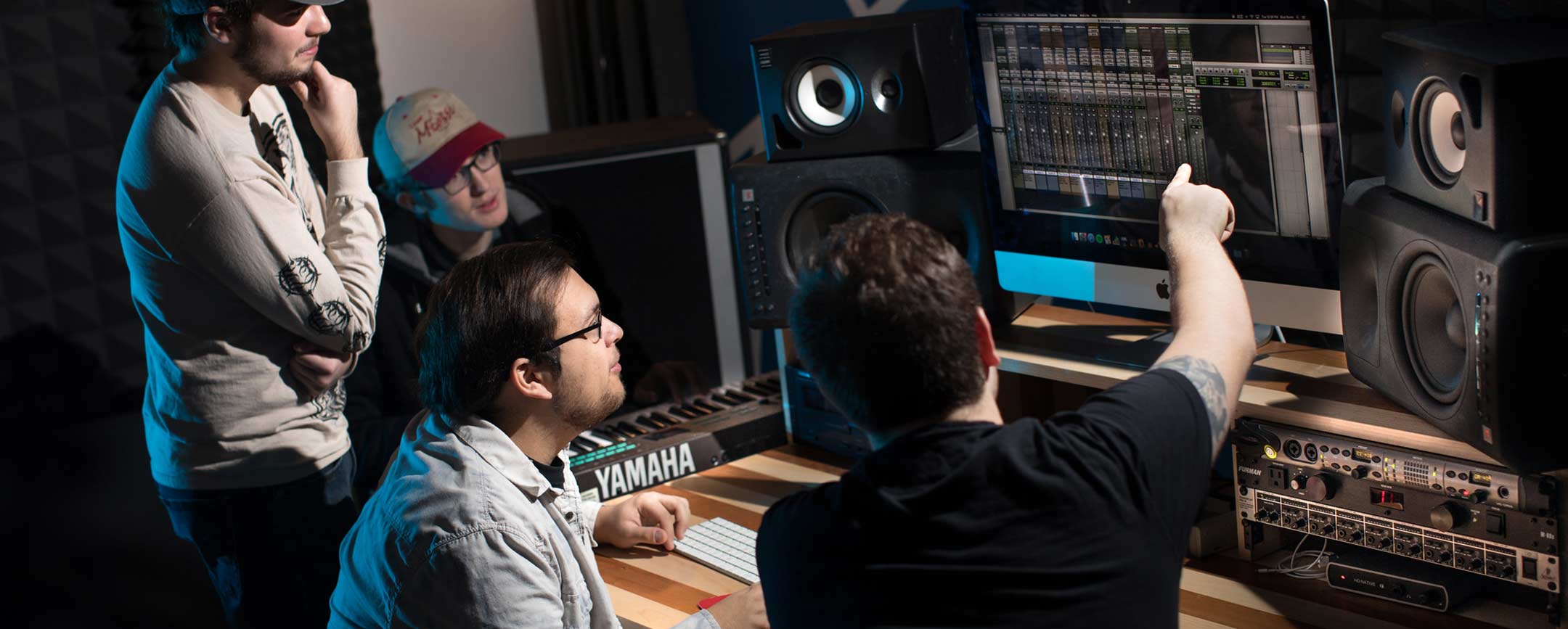 Commercial Music Technology students at Pennsylvania Western University (PennWest) work in a studio.