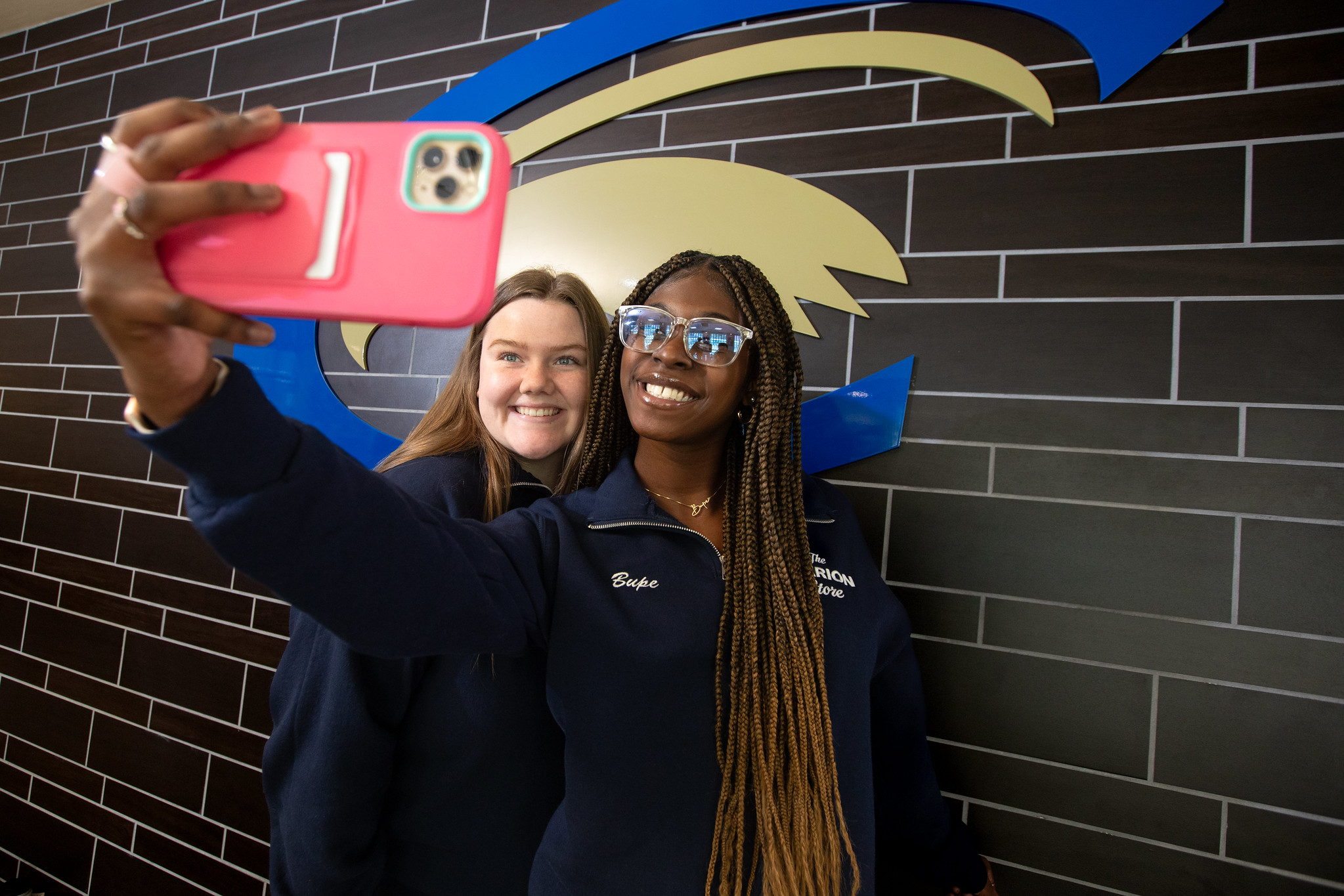 PW Clarion students posing in front of school logo in Gemmell Student Complex