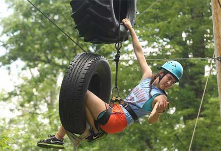 A person climbing through a hanging tire